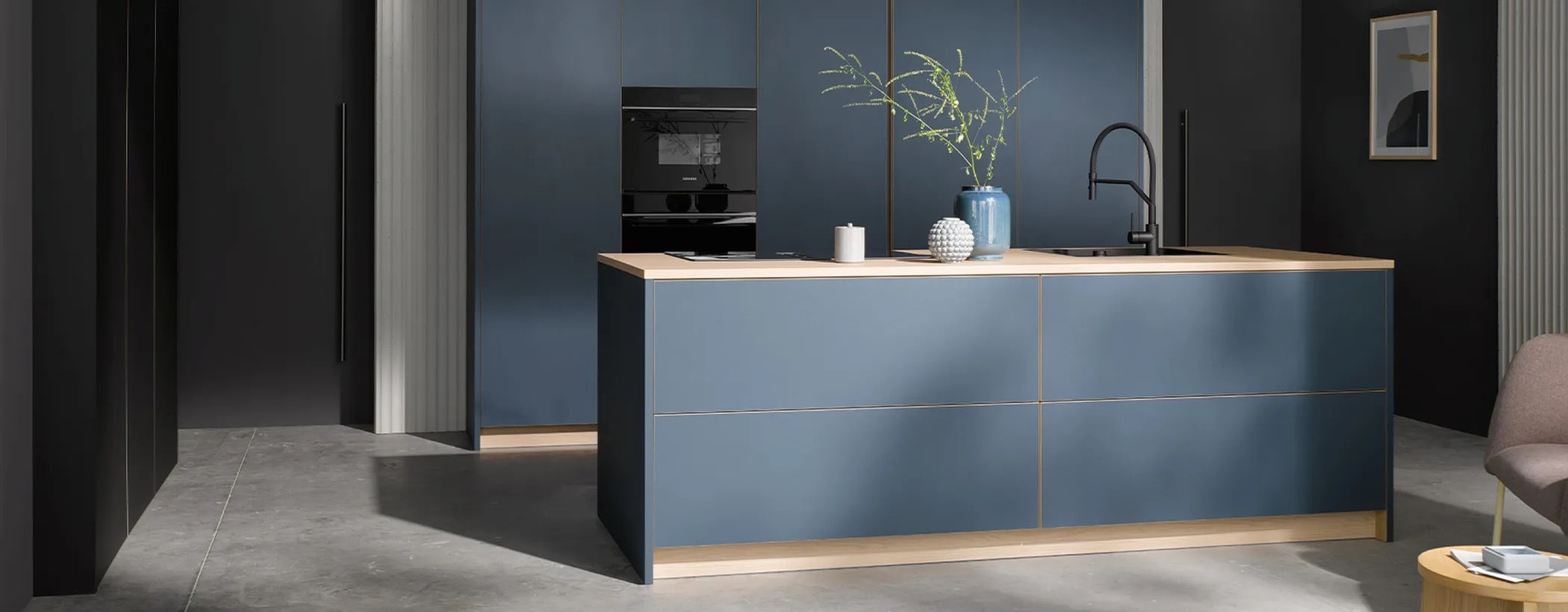 RAYN Küche in Dunkelblau mit Kochinsel und warmem Lichtband