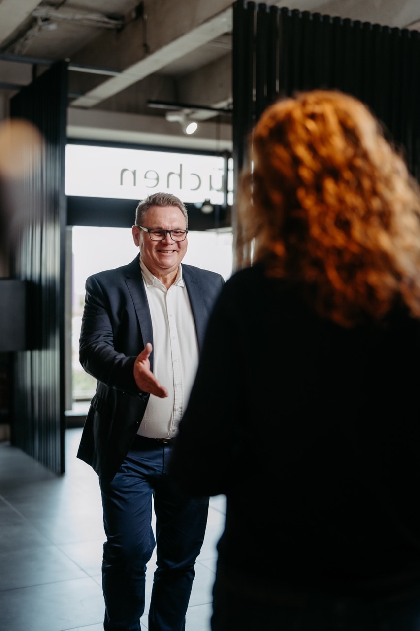 Alwin Justen begrüßt eine Kundin im Showroom