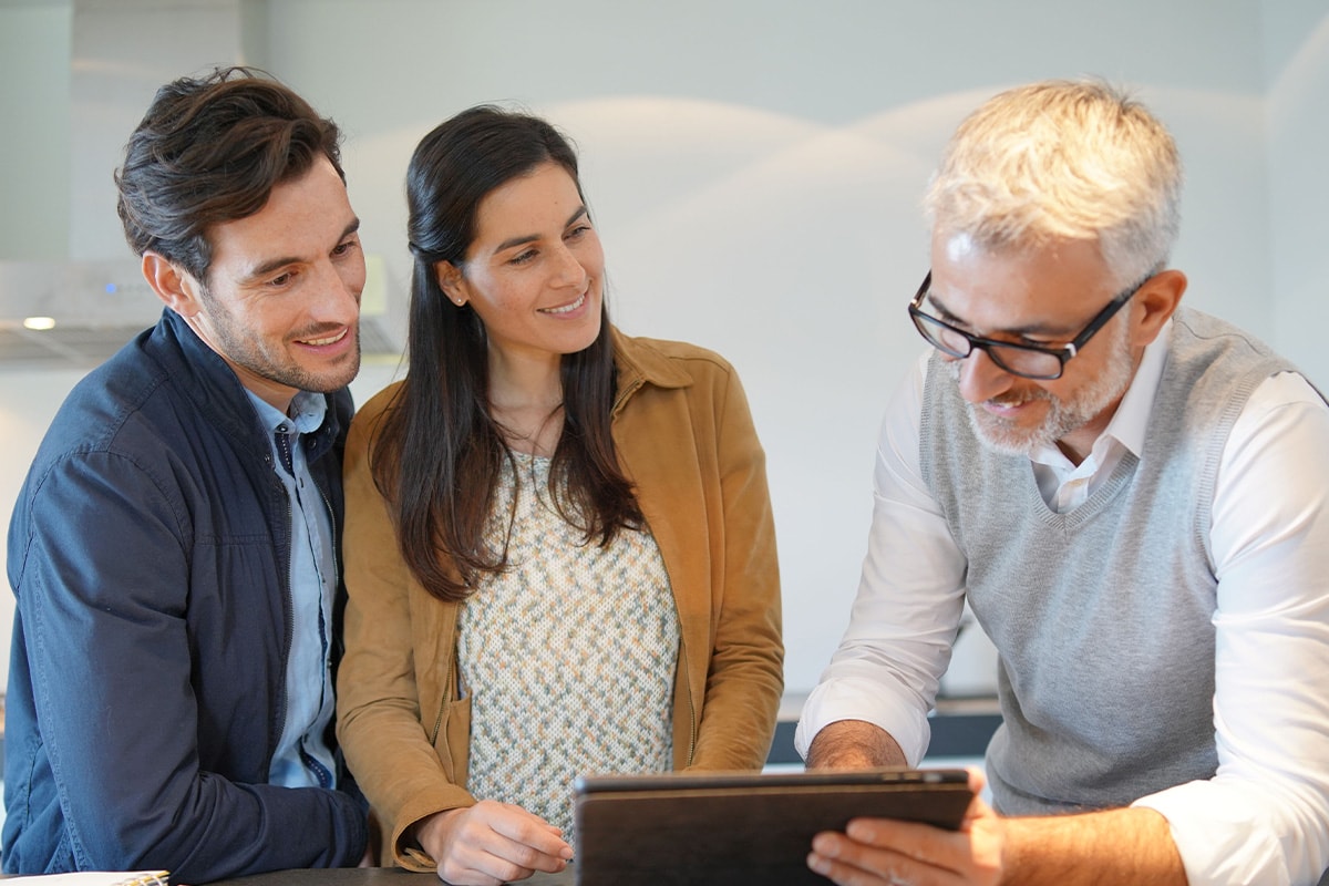 Küchenberater zeigt einem Paar Planungsdetails auf dem Tablet